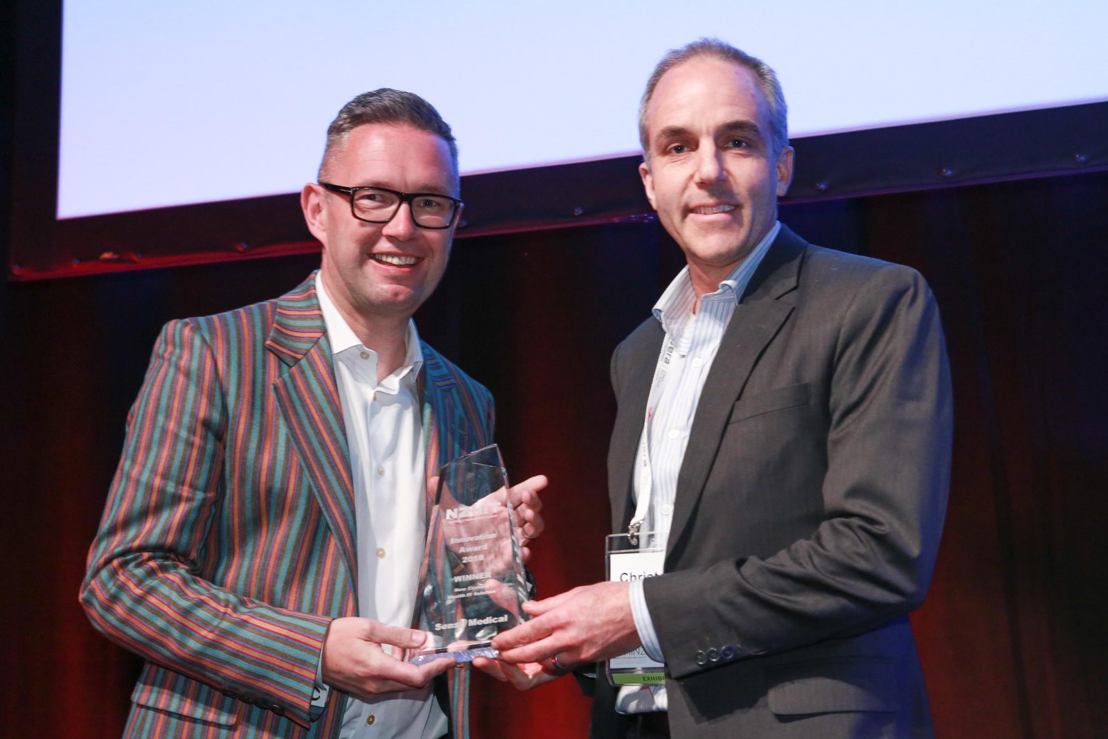 Chris Rumball of Sense Medical accepts the New Zealand Health IT Solution Award on stage at the 2018 NZHIT Innovation Awards